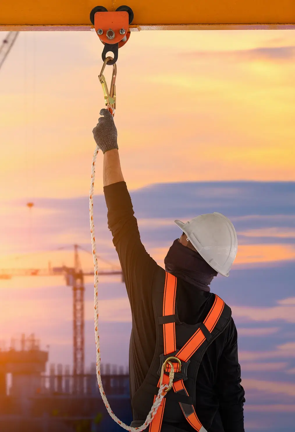 Worker attaching safety line to overhead anchor point