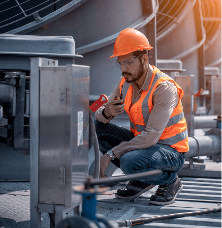 Technician inspecting industrial equipment controls